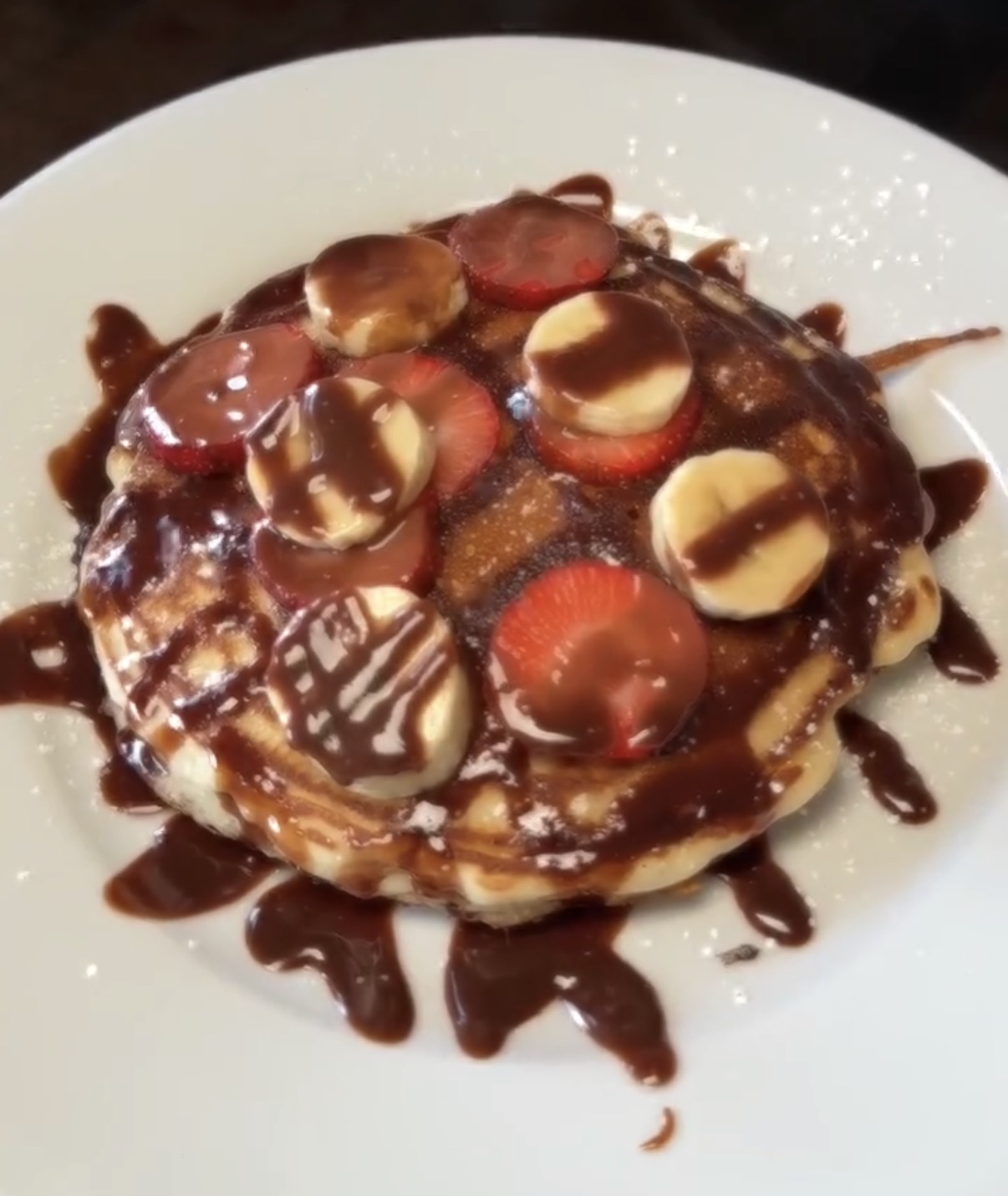 Chocolate-covered pancake with strawberries and banana from Markhor Gourmet